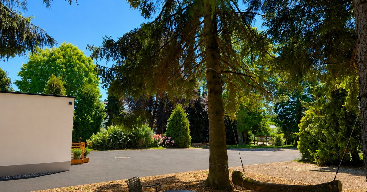 Naturgarten mit Baumschaukel unter alten Bäumen
