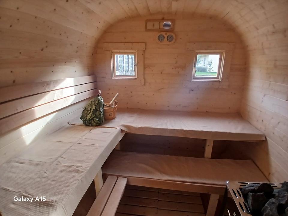 Saunaraum mit Holzbänken und Holzofen